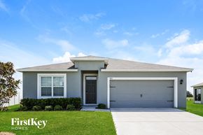 Auburndale house for rent - a white house with a garage door and a lawn