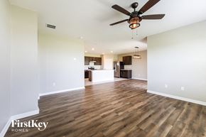 Auburndale house for rent - an empty living room with a ceiling fan and a kitchen