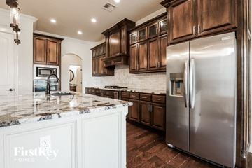 Mustang house for rent - a kitchen with wooden cabinets and stainless steel refrigerator