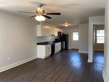 Franklinton apartment for rent - A kitchen with white cabinets and black appliances.