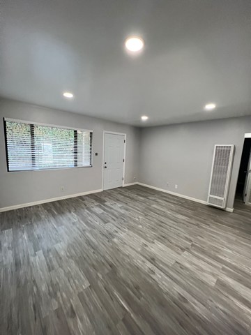 Lompoc apartment for rent - A room with a wooden floor and a window with blinds.