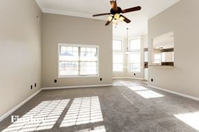 Clarksville house for rent - A spacious room with a ceiling fan and large windows.