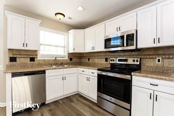 Clarksville house for rent - A kitchen with white cabinets and stainless steel appliances.