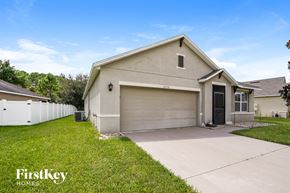 Clermont house for rent - a beige house with a driveway and a garage door