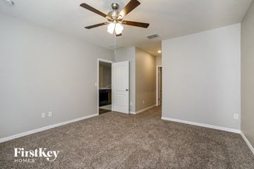 Clermont house for rent - a spacious living room with carpet and a ceiling fan