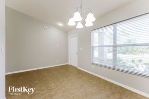 Lehigh Acres house for rent - a spacious dining room with a large window and a chandelier