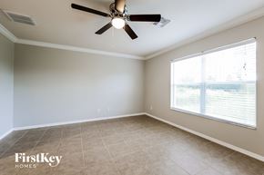 Lehigh Acres house for rent - a living room with a large window and a ceiling fan
