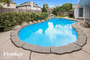 Humble house for rent - a large swimming pool in a backyard with a house