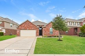 Katy house for rent - A brick house with a garage door is for sale.