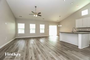 Murfreesboro house for rent - an empty living room with a kitchen and a ceiling fan