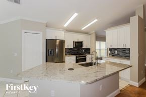 Wesley Chapel house for rent - a kitchen with white cabinets and a granite counter top