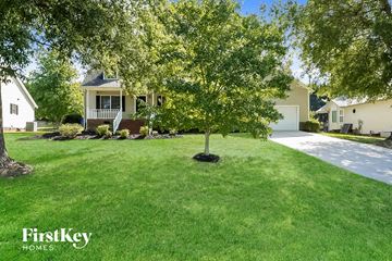 Trinity house for rent - a yard with a tree in front of a house