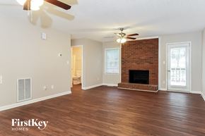 Trinity house for rent - a living room with a brick fireplace and a ceiling fan