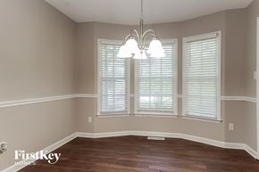 Trinity house for rent - an empty dining room with windows and a chandelier