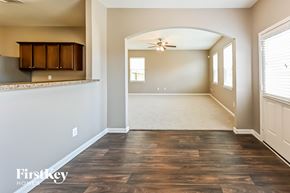 Cove house for rent - A spacious room with wooden flooring and a ceiling fan.