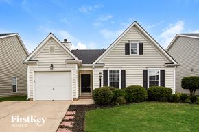 Charlotte house for rent - a white house with a white garage door and a lawn