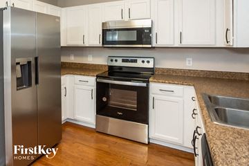 Charlotte house for rent - a kitchen with stainless steel appliances and white cabinets
