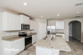 Palm Bay house for rent - a kitchen with white cabinets and granite counter tops