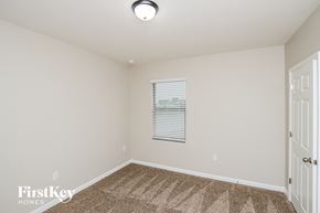 Palm Bay house for rent - a spacious room with carpeted flooring and a white door