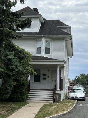 Summit apartment for rent - a white house with a car parked in front of it