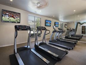 Fayetteville apartment for rent - a gym with several treadmills and a tv