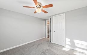 Romeoville house for rent - a bedroom with a ceiling fan and a door to a bathroom