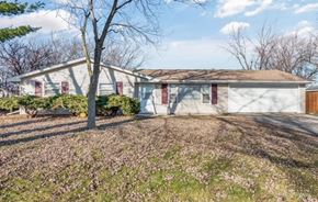 Romeoville house for rent - a small white house with a yard and a tree