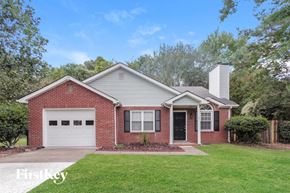 Charlotte house for rent - a brick house with a lawn and a white garage door