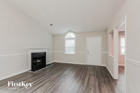 Charlotte house for rent - an empty living room with a fireplace and a door