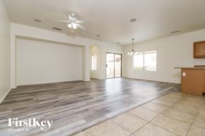 Surprise house for rent - an empty living room with a kitchen and a ceiling fan