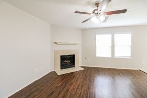 Cypress house for rent - a living room with a fireplace and a ceiling fan