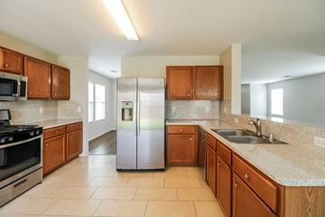 Cypress house for rent - a kitchen with wooden cabinets and a stainless steel refrigerator