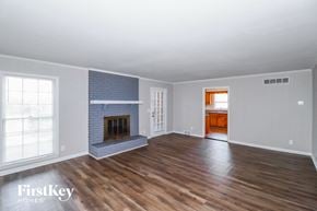 Memphis house for rent - a living room with a brick fireplace and wooden floors