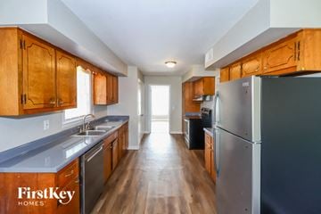 Memphis house for rent - a kitchen with stainless steel appliances and wooden cabinets