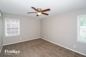 Memphis house for rent - a bedroom with carpet and a ceiling fan and two windows