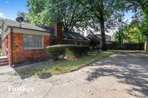 Memphis house for rent - a small brick house with a driveway and trees