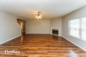 Olive Branch house for rent - an empty living room with a ceiling fan and a fireplace