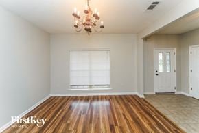 Olive Branch house for rent - the living room and dining room with wood flooring and a chandelier