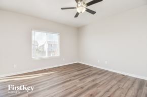 Fountain house for rent - A room with a ceiling fan and wooden flooring.