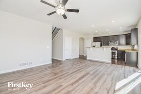 Fountain house for rent - A spacious kitchen and living room with wood flooring and a ceiling fan.