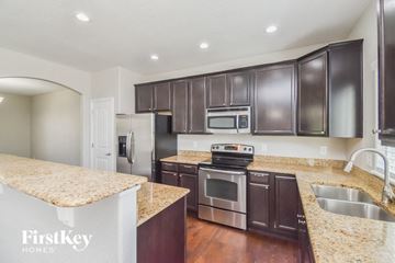 Fountain house for rent - A kitchen with dark brown cabinets and a granite countertop.