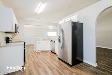 St. Augustine house for rent - A kitchen with a black fridge and white cabinets.