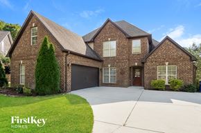 Helena house for rent - a large brick house with a driveway and a garage door