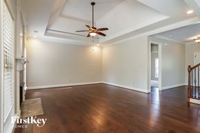Helena house for rent - an empty living room with wood floors and a ceiling fan