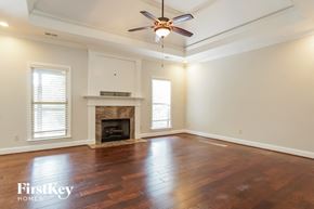 Helena house for rent - an empty living room with a fireplace and a ceiling fan