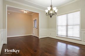 Helena house for rent - an empty dining room with wood floors and a large window