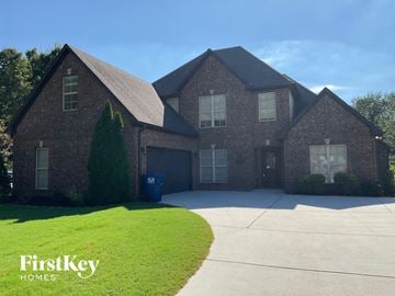 Helena house for rent - a large brick house with a driveway and a lawn