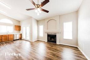 Surprise house for rent - A spacious living room with a fireplace and a ceiling fan.