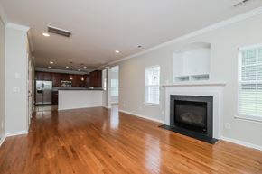 Winston-Salem house for rent - A large, empty living room with a fireplace and hardwood floors.