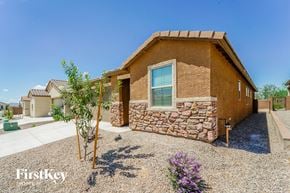 Tucson house for rent - a house with a stone facade and a gravel driveway